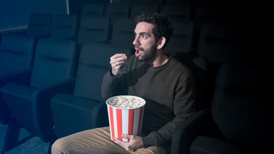man-with-popcorn-in-cinema_23-2147988965.jpg